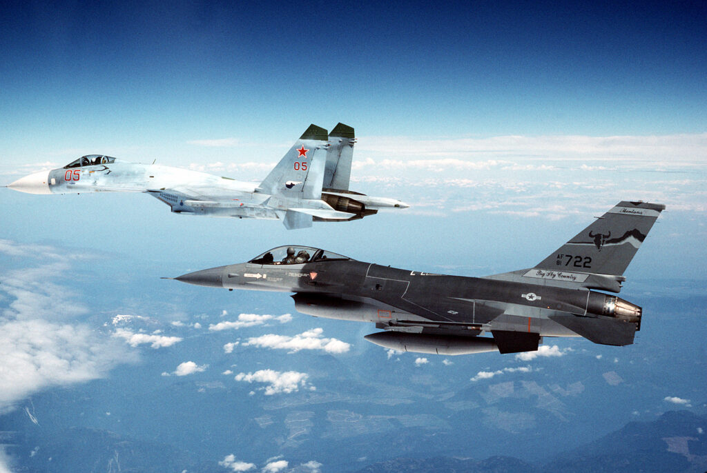 An F-16 flying through the air intercepting a Russian Su-27 Flanker.